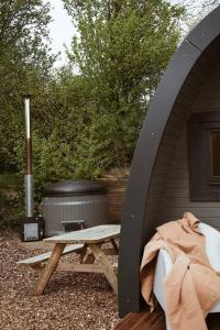 Jubbega-Schurega的住宿－Sfeervolle houten Pod met eigen hottub，房屋前的野餐桌,带烧烤架