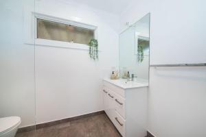 a white bathroom with a toilet and a sink at Dundas on the Beach at St Andrews in Saint Andrews Beach +32 photos