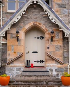 RosehallにあるInveroykel Lodge at Rosehallの赤いカップが付いた白いドアのある建物