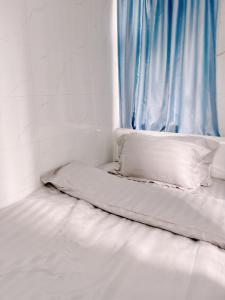 een klein bed in een kamer met een raam bij Waveflo Hostel 浪花青旅 in Hong Kong