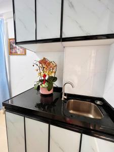 a kitchen counter with a sink and a vase of flowers at Waveflo Hostel 浪花青旅 in Hong Kong