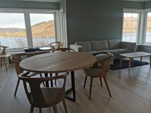 een woonkamer met een bank en een tafel en stoelen bij Fjordview Rentals in Bergen