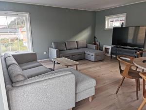 een woonkamer met 2 banken en een flatscreen-tv bij Fjordview Rentals in Bergen