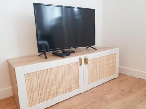 einen Flachbild-TV auf einem Fernsehstand in der Unterkunft Beautiful 2 Bedroom apartment in a quiet residence in Garches