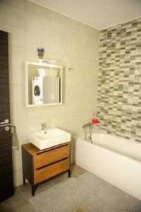 a bathroom with a sink and a tub and a microwave at Seaview-CasadiAlfio-Qawra in St Paul's Bay