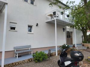 einem Roller, der vor einem Gebäude mit Balkon geparkt ist in der Unterkunft Rooms with a parking space Novi Vinodolski - 21509 in Novi Vinodolski