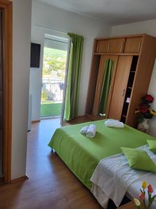 ein Schlafzimmer mit einem grünen Bett und einem großen Fenster in der Unterkunft Rooms with a parking space Novi Vinodolski - 21509 in Novi Vinodolski