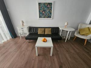 a living room with a black couch and a table at Unique Sea & City Lifestyle Studio in Limassol