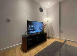 uma sala de estar com uma televisão de ecrã plano sobre uma mesa em Luxury Flat Town Centre em Reading