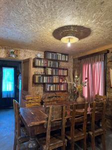 a dining room with a table and a book shelf at Odamarani in Kutaisi