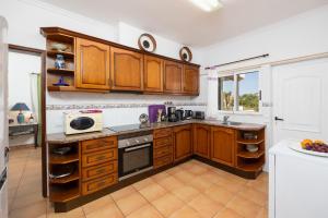 a kitchen with wooden cabinets and a counter top at Villa Sol Nascente in Porches