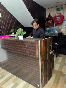 a man sitting at a counter in a restaurant at Hotel Pacific Blu in Lucknow