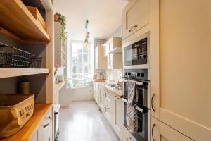 uma grande cozinha com armários e electrodomésticos brancos em Spacious 1-Bed City Centre Apartment in Aberdeen em Aberdeen