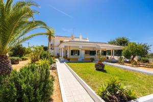 a yellow house with palm trees in front of it at Villa Sol Nascente in Porches
