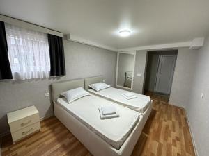 a bedroom with a bed with white sheets and a mirror at Hotel Old Boulvared in Batumi