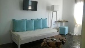 a couch with blue pillows in a room at Scorpios Hotel & Suites in Samos
