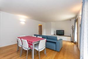 La Casa di Sofia في أليغي: غرفة معيشة مع طاولة وأريكة زرقاء