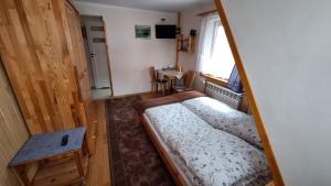 Dormitorio pequeño con cama y mesa en Domek u Gąsieniców 1 - pokoje gościnne, en Zakopane