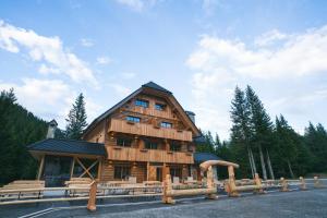 a large wooden building with a gambrel at Guesthouse Lajnar in Zgornja Sorica