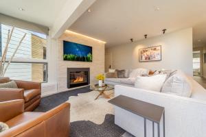 een woonkamer met een witte bank en een open haard bij New Listing Renovated 3BR with AC & Pool in Aspen