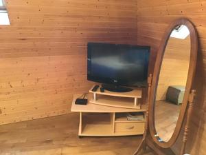 a television on a stand in front of a mirror at Studio cœur de village in Estaing