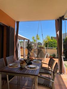 una mesa de madera y sillas en un patio en Charming Garden Apartment en "Jardins de Sa Boadella" en Lloret de Mar