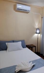 a bedroom with a white bed with a fan at Elisha's Guest House in Coron