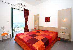 a bedroom with a bed and a large window at Aptera Paradise With Sea View in Megála Khoráfia