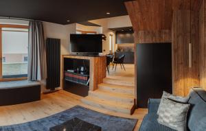 een woonkamer met een trap en een televisie bij Belmonte Tirol - Boutique Hotel in Sillian