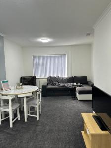 ein Wohnzimmer mit einem Sofa und einem Tisch in der Unterkunft Noormak nights in Birmingham