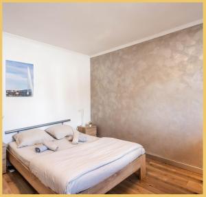 una camera da letto con un letto grande con lenzuola bianche di Cosy RDC I Ambilly ad Ambilly