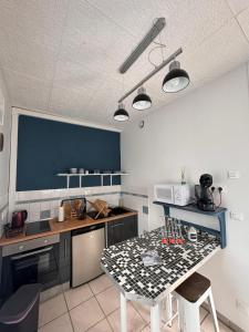une cuisine avec une table et un mur bleu dans l'établissement QUAT, à Fécamp
