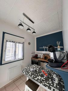 a room with a table and a blue wall at QUAT in Fécamp