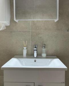ein weißes Waschbecken im Bad mit Spiegel in der Unterkunft Luxury Villa Mojito in Široki Brijeg