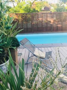 a lawn chair sitting next to a swimming pool at Belle Maison Individuelle in Rueil-Malmaison