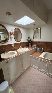 a bathroom with two sinks and two mirrors at Belle Maison Individuelle in Rueil-Malmaison