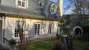ein großes weißes Haus mit einem Hof mit Gras in der Unterkunft Belle Maison Individuelle in Rueil-Malmaison