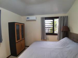 ein Schlafzimmer mit einem großen Bett und einem Fenster in der Unterkunft Paea Lodge in Paea