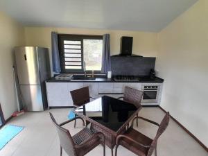 a kitchen with a table and chairs and a refrigerator at Paea Lodge in Paea