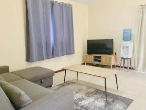 ein Wohnzimmer mit einem Sofa und einem Flachbild-TV in der Unterkunft Paea Lodge in Paea