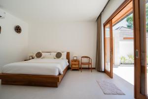 a bedroom with a bed and a sliding glass door at Villa Sakura Nusa Dua in Nusa Dua +14 photos