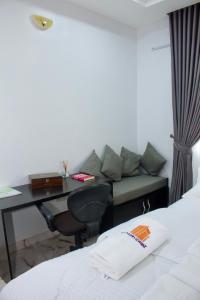 um quarto de hotel com uma secretária e um sofá em The Hidden Gem Wuye em Abuja