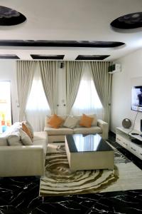 uma sala de estar com dois sofás e uma televisão em The Hidden Gem Wuye em Abuja