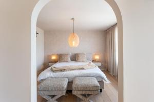 ein Schlafzimmer mit einem großen Bett mit 2 Stühlen in der Unterkunft Maison Noomi in Knokke-Heist