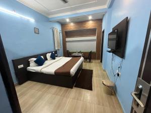 Hotel devoy inn by namastexplorer في ريشيكيش: غرفة نوم بسرير وتلفزيون في غرفة