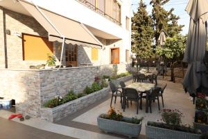 un patio con mesa, sillas y sombrilla en VILA Eljus en Durrës