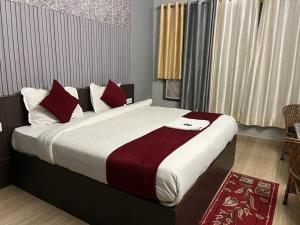 a bedroom with a large bed with red pillows at Hotel devoy inn by namastexplorer in Rishīkesh