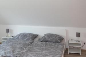 a bed in a bedroom with two night stands at Haus Seewind in Wesselburen