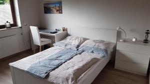 Schlafzimmer mit einem Bett und einem Schreibtisch mit einem Computer in der Unterkunft Haus Seewind in Wesselburen