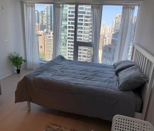 多倫多的住宿－Toronto Premier INN，卧室内的一张床铺,设有大窗户